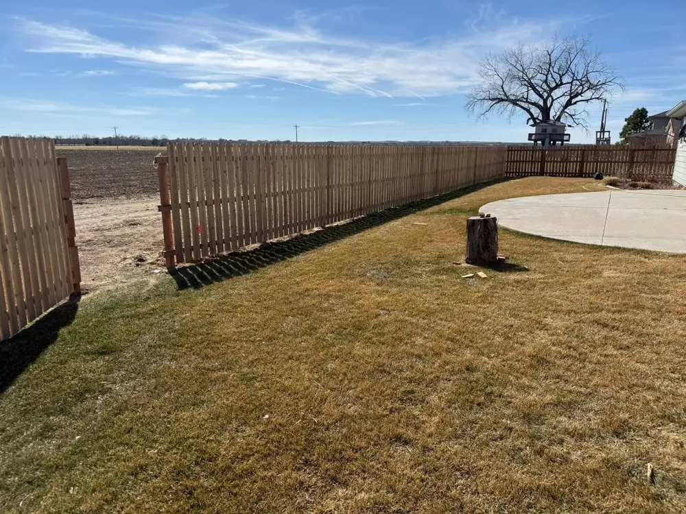 Finished wood privacy fence along a green lawn