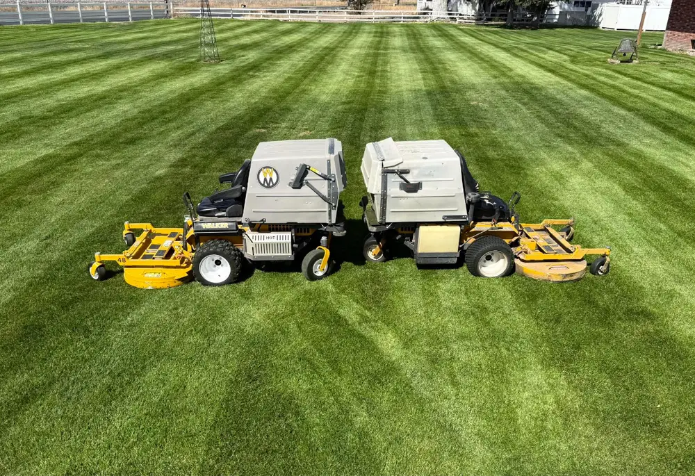Two Walker mowers on a freshly striped lawn